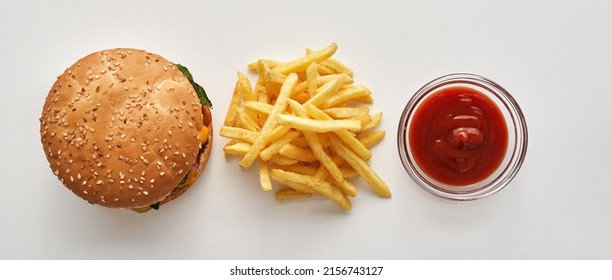 Top View Of Classic Fast Food Cafe Set From Burger, French Fries And Sauce In Bowl. Unhealthy Eating. High-calorie Fresh Delicious And Appetizing Junk Food. Isolated On White Background. Studio Shoot