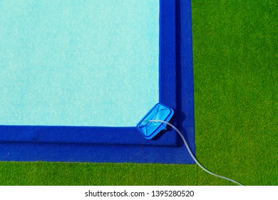 Top View Cleaning Net At On The Edge Of The Pool Is Green And Blue Artificial Grass.