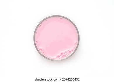 Top view of  clear glass filled with strawberry flavored nonfat skim milk showing on white background, with clipping path.