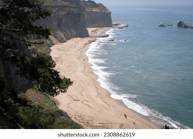 Top view of cliffs of California coast, rocky shore, sandy beach and ocean waves - Powered by Shutterstock