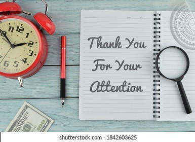 Top View Of Clock,magnifying Glass,bank Note, Ruler, Pen And Notebook Written With Text “Thank You For Your Attention” On Wooden Background