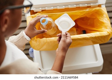 Top View Close Up Of African-American Boy Putting Plastic In Recycling Bins At Home, Copy Space