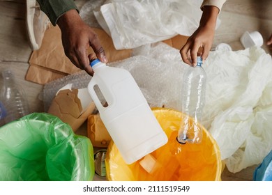 Top view close up of African-American father and son putting plastic in recycling bins at home, copy space - Powered by Shutterstock