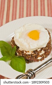 
Top View, Close Distance Of A Quinoa Basil Mozzarella And Sunny Side Up Egg, On A Round White Plate, Handle Of An Artisan Fork On Red And White Striped Towel