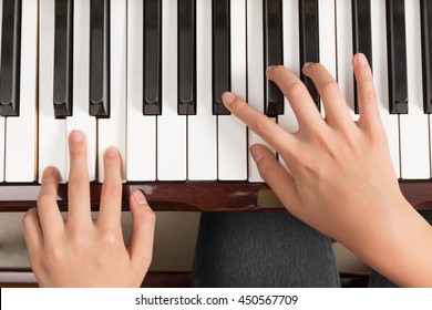 Top view close up of female's both hands playing piano