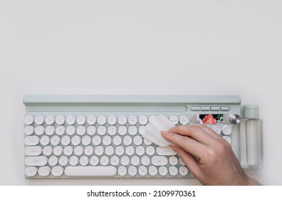 Top View Close Up Of Hand Wiping Keyboard With Sanitizing Wipes While Working At Desk In Post Pandemic Office, Copy Space