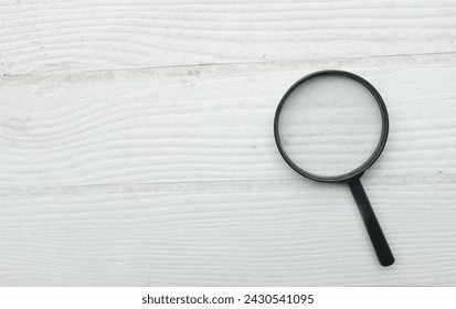 top view and close up magnifying glass loupe search symbol isolate on the wooden table white backdrop.Searching information data on internet ,Minimal creative concept.  - Powered by Shutterstock