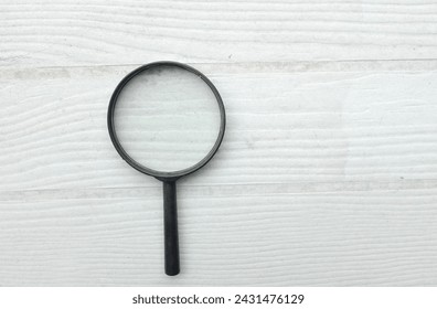 top view and close up magnifying glass loupe search symbol isolate on the wooden table white backdrop.Searching information data on internet ,Minimal creative concept.  - Powered by Shutterstock