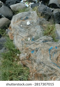 Top view close up of old tangled fishing nets and ropes piled on coastal rocks