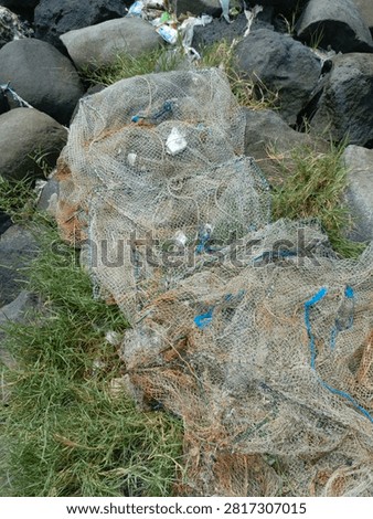 Top view close up of old tangled fishing nets and ropes piled on coastal rocks