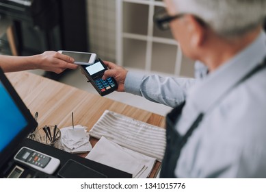 NFC 기술을 통해 여성 고객이 비용을 지불하고 무접촉 결제 단말기를 들고 있는 남성 근로자의 모습을 가장 잘 보여주는 사진 스톡 사진