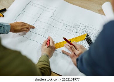 Top view close up of two architects discussing floor and furniture plans, copy space - Powered by Shutterstock