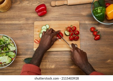 Top View Close Up Of Unrecognizable Black Man Cutting Vegetables On Wooden Table While Cooking In Kitchen, Copy Space