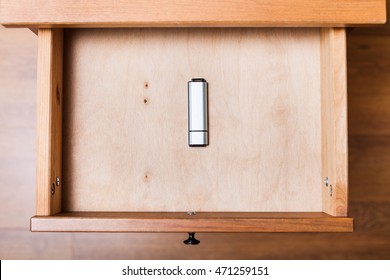 top view of closed flash drive in open drawer of nightstand