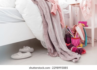 Top view, close-up. Colored clothes, sneakers, a backpack, a blanket, a briefcase are scattered on the floor in a big mess. The room of a teenager who does not want to keep order - Powered by Shutterstock