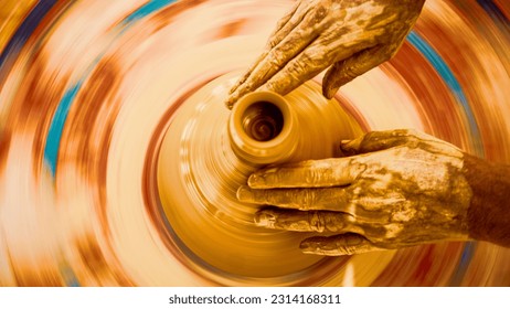 A top view closeup of a craftsman's hands working on the pottery wheel - Powered by Shutterstock