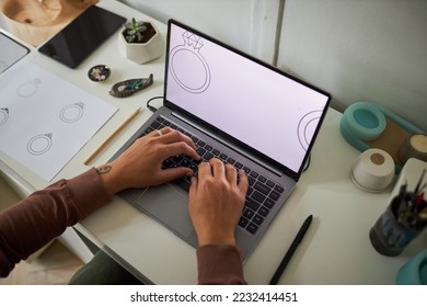 Top view closeup of creative artist typing at laptop keyboard and designing jewelry, copy space - Powered by Shutterstock