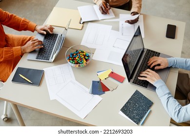 Top View Closeup Of Creative Team Of Three Using Laptops While Working Together At Table, Office Collaboration Background