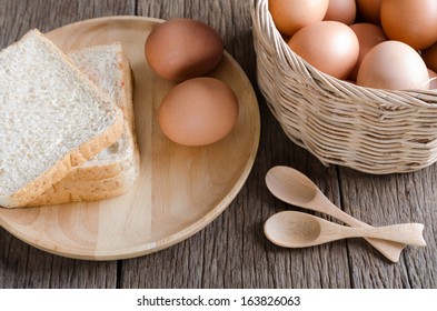 Top view closeup eggs and bread with basket and wooden spoon
