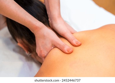 Top view close-up of a masseuse giving a cervical neck massage to a patient - Powered by Shutterstock