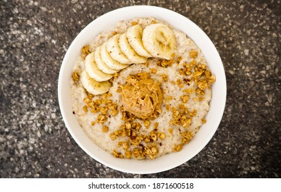 A top view closeup of oatmeal  with bananas, nuts, and peanut butter on a bowl - Powered by Shutterstock