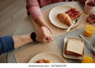 Top view closeup of senior couple holding hands at dinner table enjoying love in retirement copy space - Powered by Shutterstock