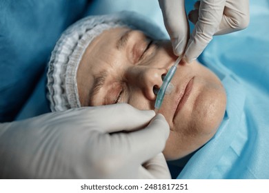 Top view closeup of surgeon adjusting oxygen tube for patient lying on operating table copy space - Powered by Shutterstock