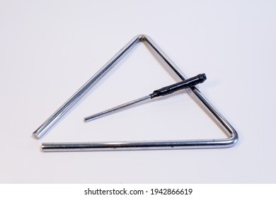 A Top View Closeup Of A Triangle Instrument Placed On A White Background