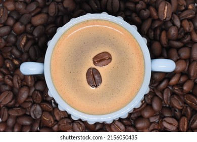 A top view of a coffee cup surrounded by beans