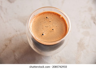 Top view of coffee in glass with double walls on concrete background