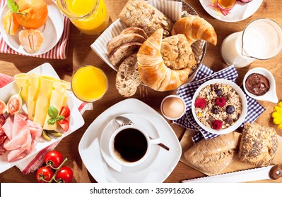 Top view of coffee, juice, fruit, bread and meat on table