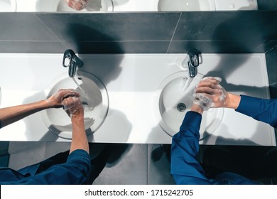 Top View . Colleagues Wash Their Hands In The Office Restroom