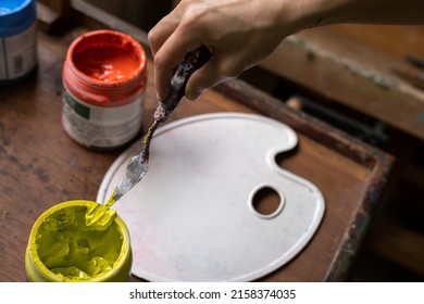 Top View Of Colored Acrylic Paint Pots, Plastic Palette And Palette Knife Used For Painting In The Art Studio. Space For Copying. Concept Of Artist And Hobby.