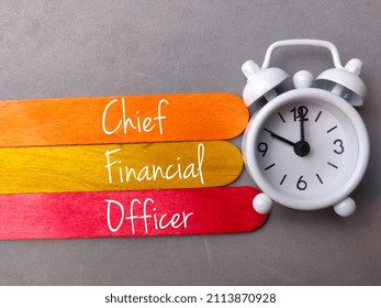 Top View Colored Ice Cream Stick And Clock With Text Chief Financial Officer On Gray Background