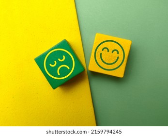 Top View Colored Wooden Cube With The Happy And Unhappy Face Icons.