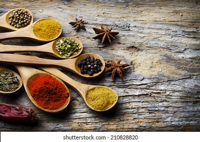 Top view of colorful spices on rustic wooden table with copyspace. Cooking and culinary concept.