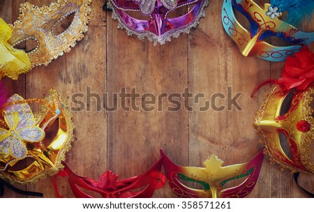 top view of colorful Venetian masquerade masks on wooden table. retro filtered image
