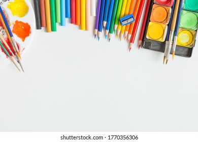 Top View Of Colorful Watercolor Palette, Paintbrush, Colored Pencils, Ruler And Drawing Equipment On White Background And Copy Space