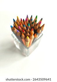 
Top view of colorful wooden pencils neatly arranged in a transparent container on a white background. Bright hues and clean composition make this image ideal for creative, educational, or office-rela