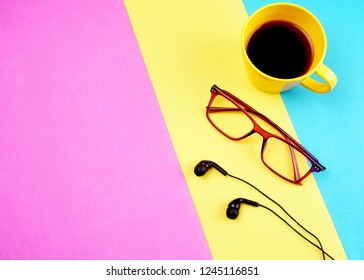 Top view of colorful working table have Headphones,mobile phone and cup of tea on color blue, Yellow and pink background for create idea for business or design. Relax time listen song (flat lay). - Powered by Shutterstock