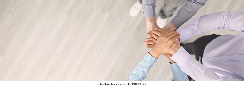 Top View Of Company Employees Putting Hands Together Before Good Deal. Support And Team Work. Worker In Suits. Copy Space In Left Side. Development And Success. Business And Career Growth Concept
