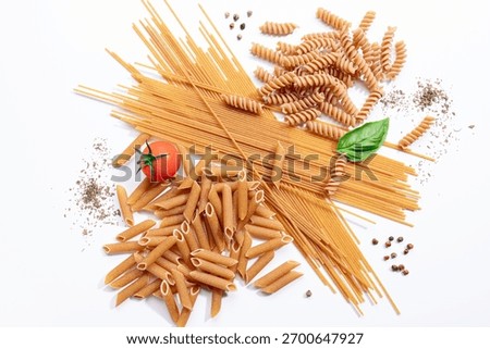 Top view composition of assorted whole wheat pasta isolated on a white background.