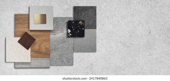top view composition of interior material samples including stone granite tiles, terrazzo, wooden vinyl flooring tile, gold stainless, quartz placed on grey concrete table with blank space for design.