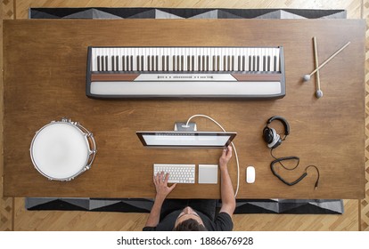 Top view of a composition of musical instruments on a wooden table in a recording studio. Musician's workplace for creativity.