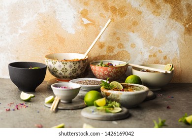 
Top view composition of various Asian food in bowl on grey background