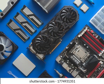 Top View Of Computer Parts With Harddisk, Ram, CPU, Graphics Card, And Motherboard On Blue Table Background.