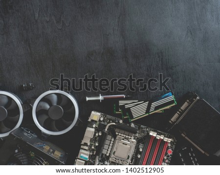 top view of computer parts with harddisk, ram, CPU, graphics card, and motherboard on black table background.