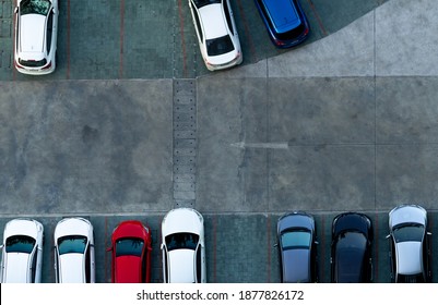 Top view concrete car parking lot. Aerial view of car parked at car parking area of apartment. Outdoor parking space with empty slot. One way traffic sign on road. Above view outside car parking lot.