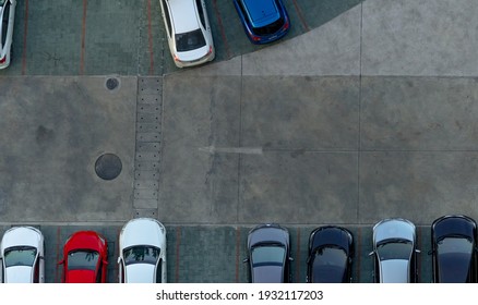 Top View Concrete Car Parking Lot. Aerial View Of Car Parked At Car Parking Area Of Apartment. Outdoor Parking Space With Empty Slot. One Way Traffic Sign On Road. Above View Outside Car Parking Lot.