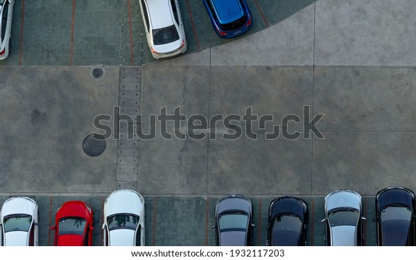 Top view concrete car parking lot. Aerial view of\
car parked at car parking area of apartment. Outdoor parking space\
with empty slot. One way traffic sign on road. Above view outside\
car parking lot.